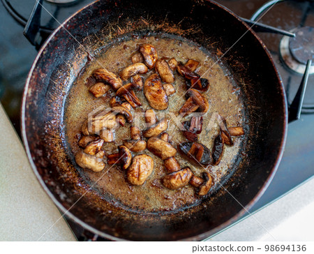 beautiful fried mushrooms champignon in background cast iron pan 98694136