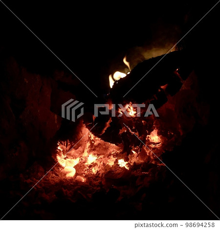 Beautiful flame brown wood dark black coal on bright yellow fire inside metal brazier Beautiful flame brown wood dark black coal on bright yellow fire inside metal brazier 98694258