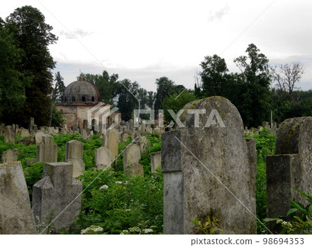 Old abandoned Jewish cemetery with stone graves between trees Old abandoned Jewish cemetery with stone graves between trees 98694353