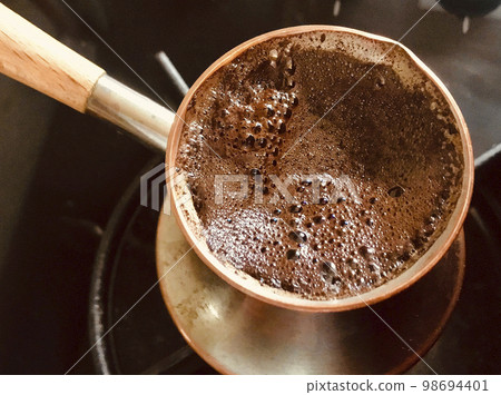 Barista preparing hot tasty drink from copper turk Barista preparing hot tasty drink from copper turk 98694401