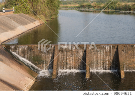 The water flow pass the weir from upper level to lower level. The water flow pass the weir from upper level to lower level. 98694631