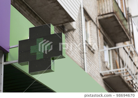 medical cross on pharmacy building 98694670