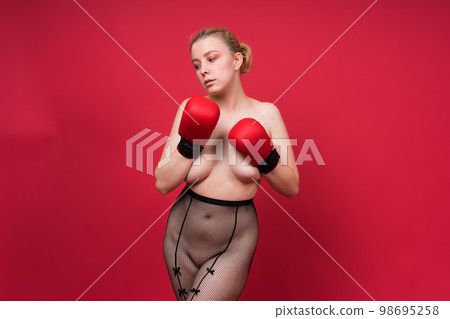 Seductive confident female boxer with gloves studio, sporty woman posing looking at camera. 98695258