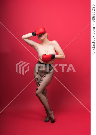 Seductive confident female boxer with gloves studio, sporty woman posing looking at camera. 98695259