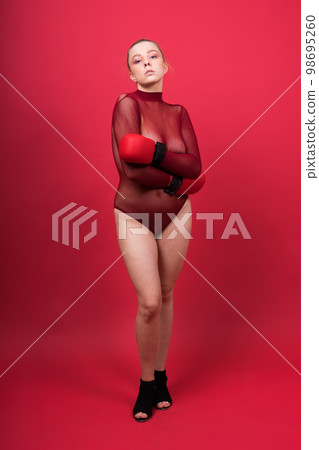 Seductive confident female boxer with gloves studio, sporty woman posing looking at camera. 98695260