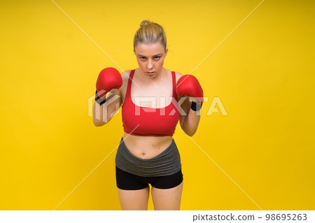 Portrait of confident young woman wearing red boxing gloves and black sports  bra Stock Photo