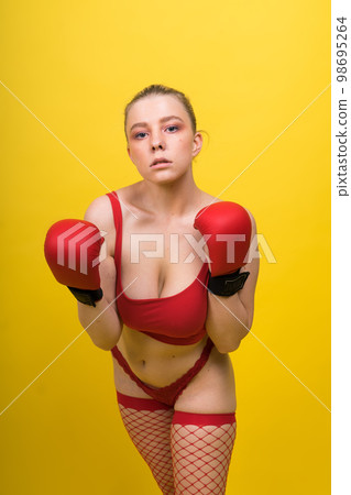 Seductive confident female boxer with gloves studio, sporty woman posing looking at camera. 98695264
