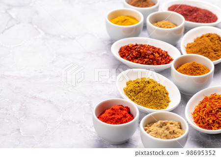 Various dried spices in small bowls 98695352