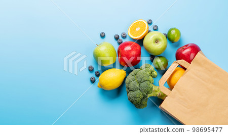 Shopping paper bag full of healthy food on blue 98695477
