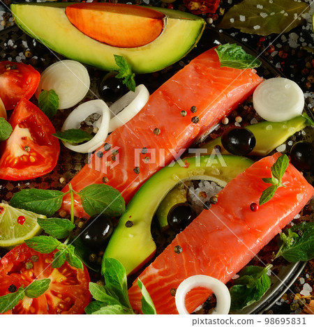 Salmon fillet, various spices and vegetables on a black . 98695831