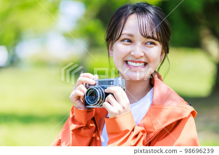 在美麗的綠色公園拍照的相機女孩 在美麗的綠色公園拍照的相機女孩 98696239