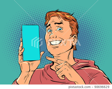 A man with red hair smiles and points to the phone. Product demonstration or offer on smartphone. The joy of a perfect purchase. Pop Art Retro 98696629