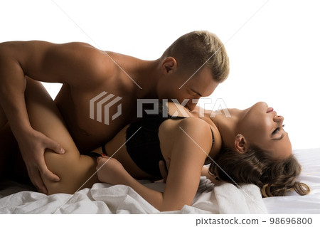 Desired couple kissing on bed during foreplay 98696800