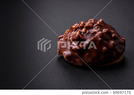 Delicious chocolate tart with nuts on a black ceramic plate 98697178