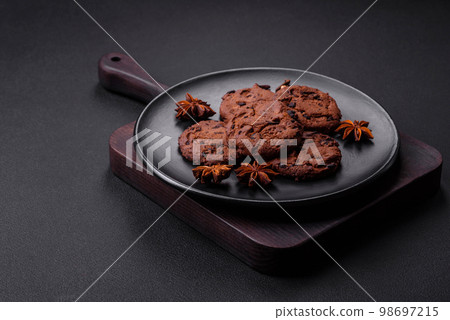 Delicious chocolate cookies with nuts on a black ceramic plate 98697215