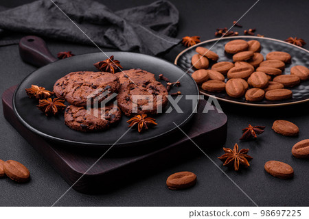 Delicious chocolate cookies with nuts on a black ceramic plate 98697225