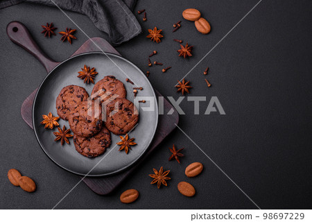 Delicious chocolate cookies with nuts on a black ceramic plate Delicious chocolate cookies with nuts on a black ceramic plate 98697229