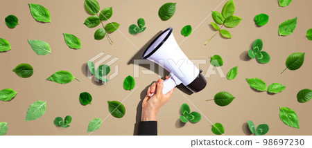 Person holding a megaphone with green leaves 98697230