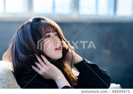 在別緻房間的沙發上放鬆的酷女人 98698973