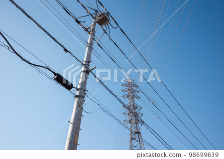 Intersecting wires in a residential area, high-voltage power lines, and a clear sky a-4 cool color 98699639