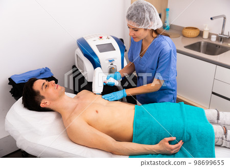Man getting laser hair removal procedure Man getting laser hair removal procedure 98699655