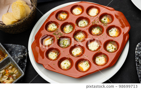 Baked Provolone cheese slices with spicy sauce and dried herbs 98699713