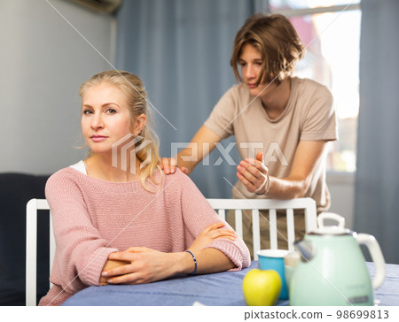Teenage boy asking for forgiveness from upset mother Teenage boy asking for forgiveness from upset mother 98699813