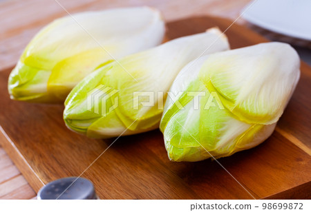 Head of belgian endive chicory on wooden table 98699872