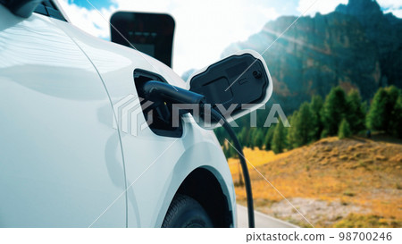 Progressive travel concept by EV car in remote mountain with charging station. Progressive travel concept by EV car in remote mountain with charging station. 98700246
