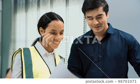 Competent investor investor discuss and brainstorm with engineers on blueprint. 98701071