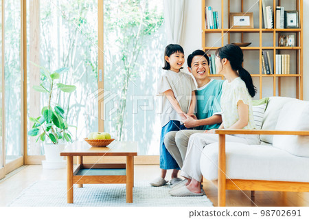A young family gathering in the living room　 98702691