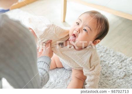 A troublesome baby hates changing clothes A troublesome baby hates changing clothes 98702713