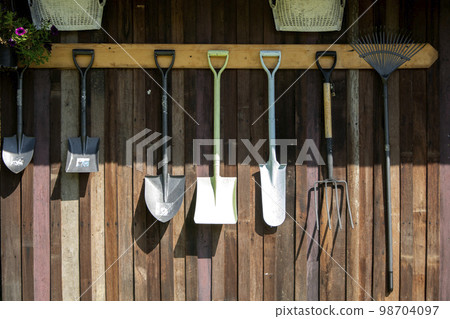 Gardening tools hang on Wooden wall, tool concept Gardening tools hang on Wooden wall, tool concept 98704097