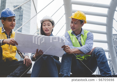 Civil Construction engineer teams shaking hands together wear work helmets worker on construction site. Foreman industry project working engineer teamwork. Two asian engineer team shake hands together 98705698