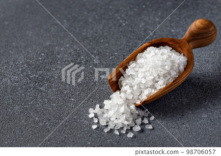 sea salt in wooden scoop on grey background 98706057