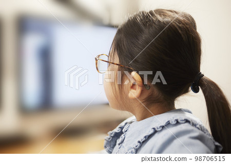 Child girl watching video distribution on computer monitor Child girl watching video distribution on computer monitor 98706515