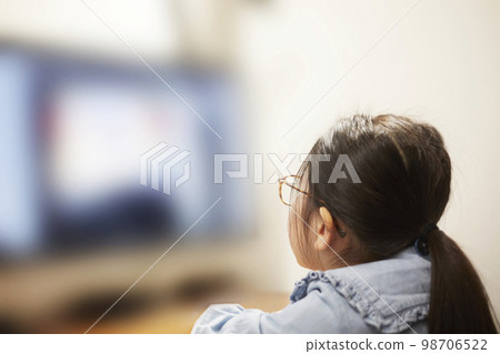 Child girl watching video distribution on computer monitor Child girl watching video distribution on computer monitor 98706522