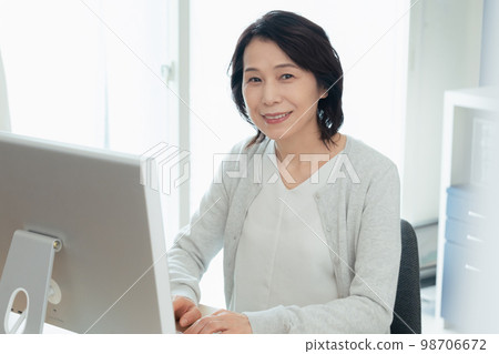 Middle woman working on personal computer 98706672