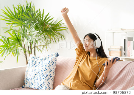 Asian teenager listening to music on smartphone with headset enjoy. Asian teenager listening to music on smartphone with headset enjoy. 98706873