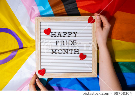 HAPPY PRIDE MONTH frame on Rainbow LGBTQIA flag made from silk material. Symbol of LGBTQ pride month. Equal rights. Peace and freedom. Support LGBTQIA community HAPPY PRIDE MONTH frame on Rainbow LGBTQIA flag made from silk material. Symbol of LGBTQ pride month. Equal rights. Peace and freedom. Support LGBTQIA community 98708304