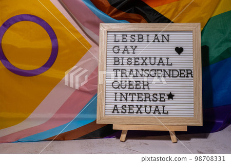 LGBTQIA description frame on Rainbow LGBTQIA flag made from silk material. LESBIAN, GAY, BISEXUAL, TRANSGENDER, QUEER, INTERSEX, ASEXUAL Symbol of LGBTQ pride month. Equal rights. Peace and freedom LGBTQIA description frame on Rainbow LGBTQIA flag made from silk material. LESBIAN, GAY, BISEXUAL, TRANSGENDER, QUEER, INTERSEX, ASEXUAL Symbol of LGBTQ pride month. Equal rights. Peace and freedom 98708331