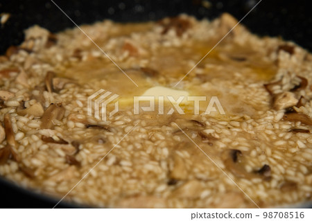 Process of cooking risotto. Arborio rice in frying pan at home kitchen. Italian cuisine dish Process of cooking risotto. Arborio rice in frying pan at home kitchen. Italian cuisine dish 98708516