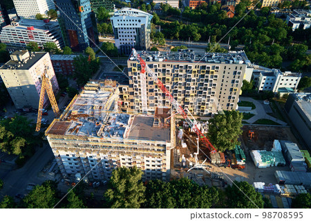 Aerial view of construction site with residential building under construction. Tower crane on construction site in city 98708595