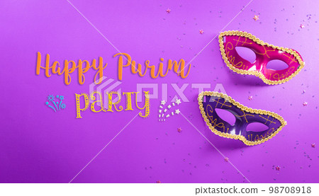 Happy Purim carnival decoration concept made from mask and sparkle star on purple background. (Happy Purim in Hebrew, jewish holiday celebrate) 98708918