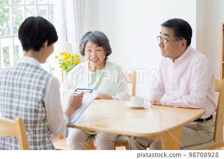 A woman explaining to a senior couple 98708928