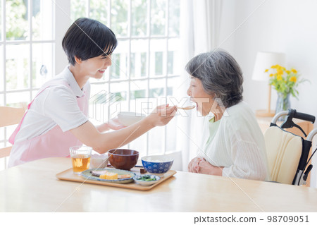 Nursing care image A caregiver assisting with meals 98709051