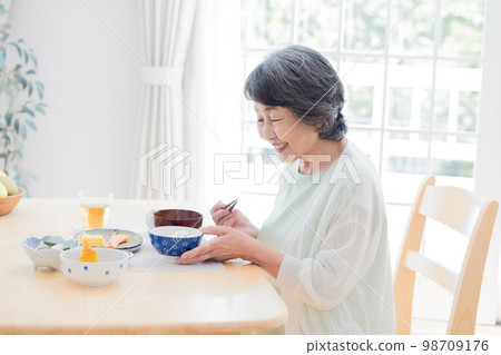 Meal scene Senior woman eating Meal scene Senior woman eating 98709176