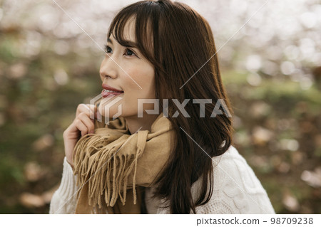 A smiling woman wearing a winter image knit and muffler A smiling woman wearing a winter image knit and muffler 98709238