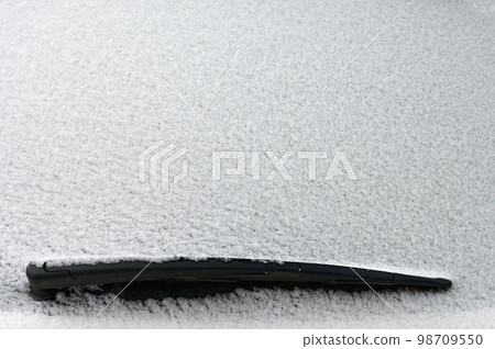 Snowy windshield on a car with wipers. Winter concept for traffic and road safety. Snowy windshield on a car with wipers. Winter concept for traffic and road safety. 98709550
