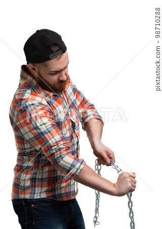 Beared guy in cap and checked shirt emotionally trying to break the iron chain on white background  98710288